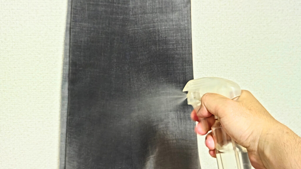 スラックスに霧吹きで水をかけている。