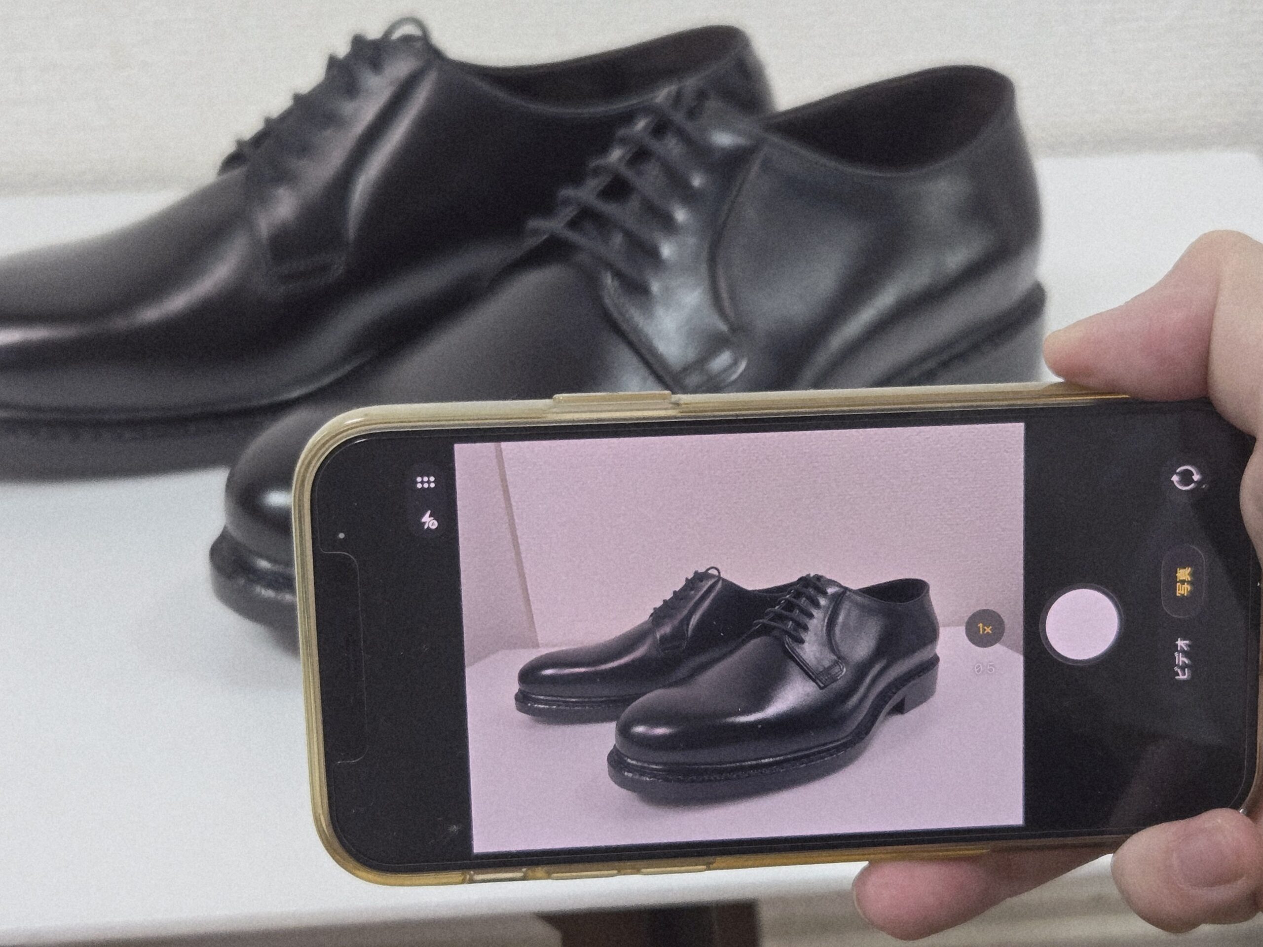 自然光の入る室内で革靴を撮影している様子